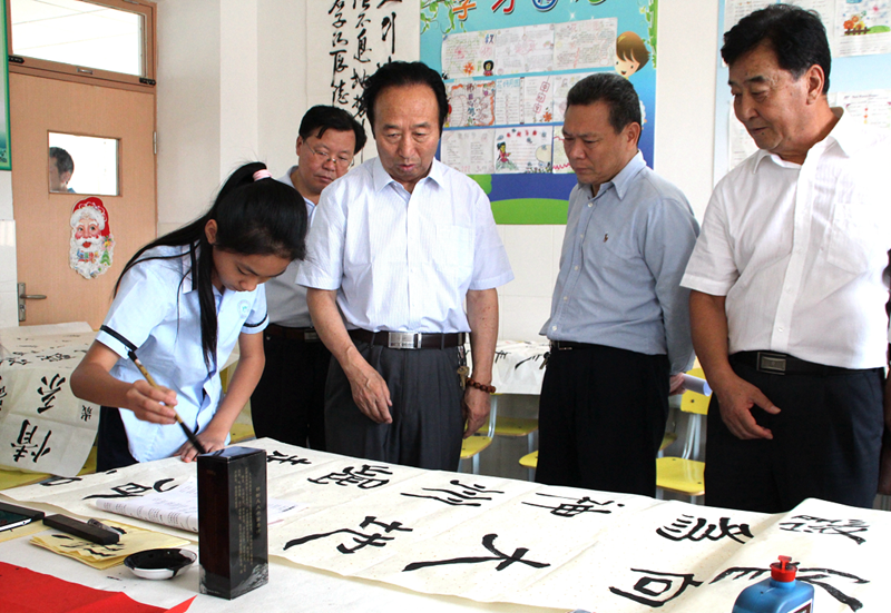 潍城区老年大学“五老”志愿者在潍坊外国语学校圣基分校指导学生书法创作.png